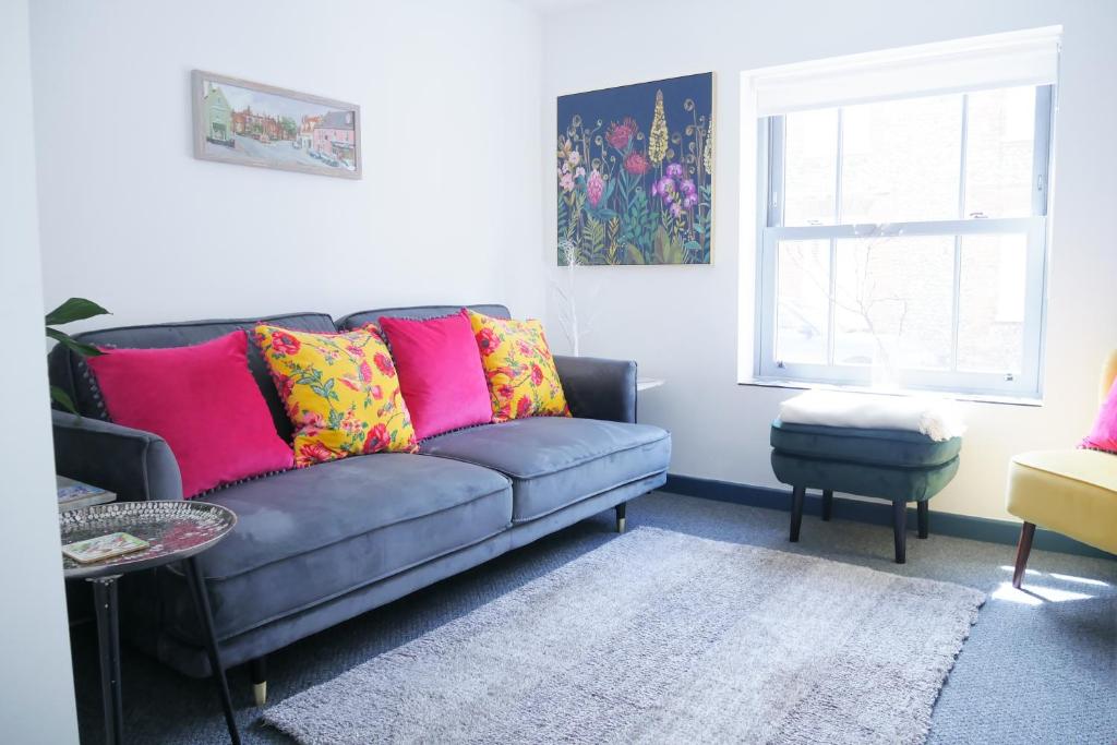 a living room with a couch and a window at New street Luxury town house in the centre of Holt with free PARKING for one car in Holt