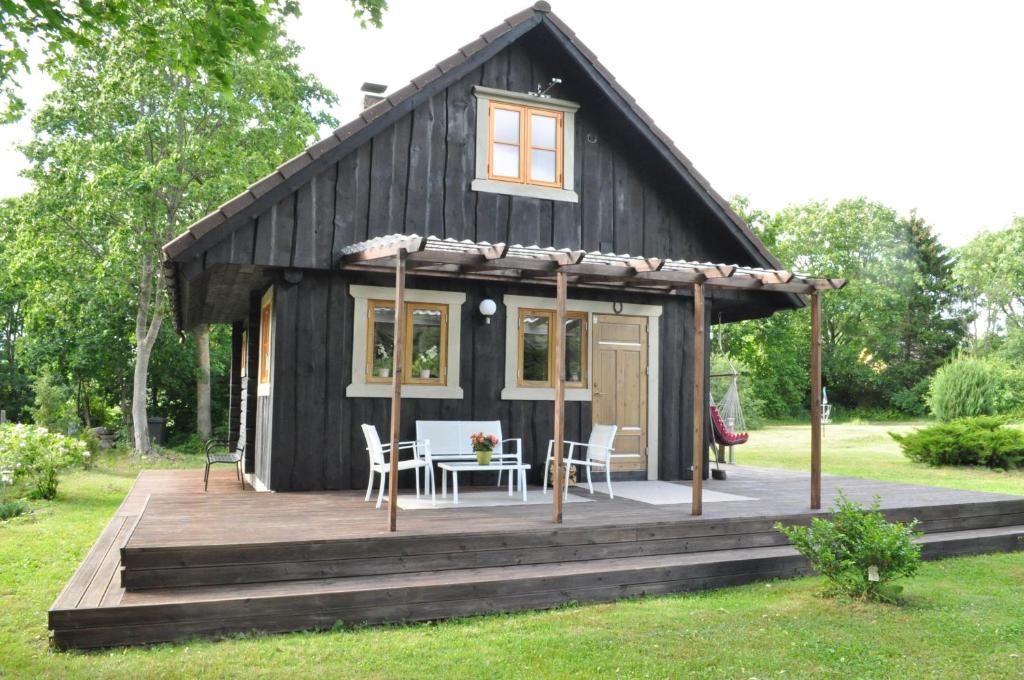 Cabaña negra con mesa y sillas en la cubierta en Villa Verde, en Kihelkonna