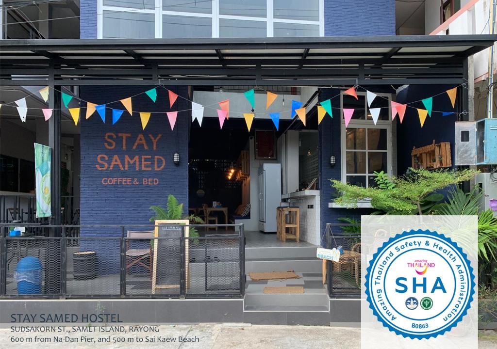 a restaurant with flags and a sign in front of it at Stay Samed Hostel in Ko Samed