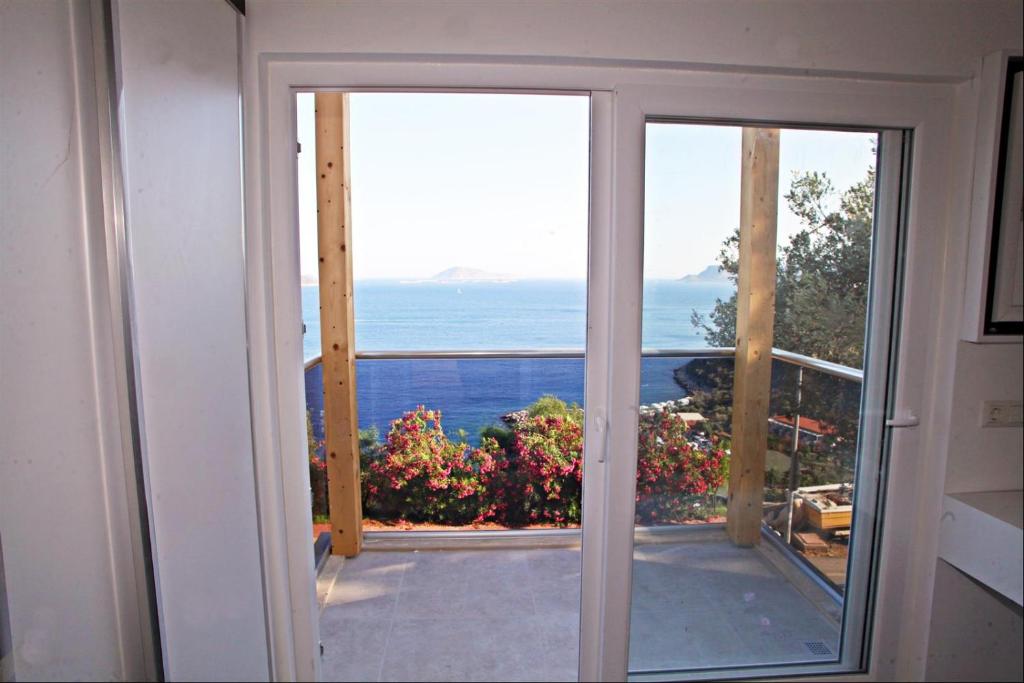 an open door to a balcony with a view of the ocean at Blue Island Luxury Hotel Adults Only in Kaş