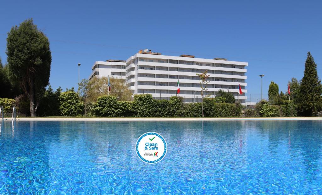 una gran piscina de agua con un edificio al fondo en Curia Clube en Curia