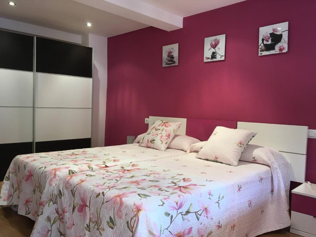 um quarto com paredes roxas e uma cama grande em El Capricho em Cue