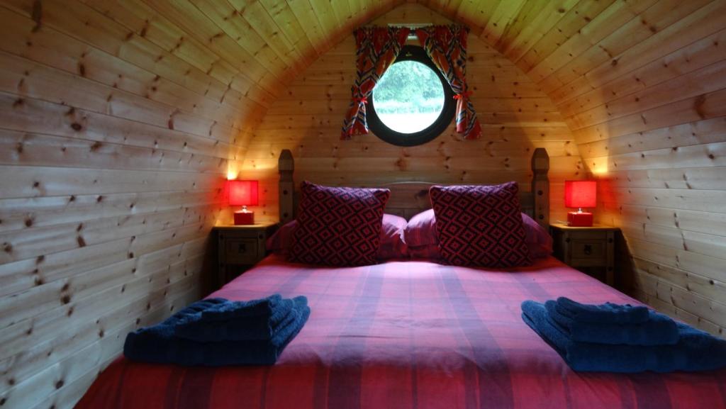 a bedroom with a bed in a wooden cabin at Woodbatch Camping & Glamping in Bishops Castle