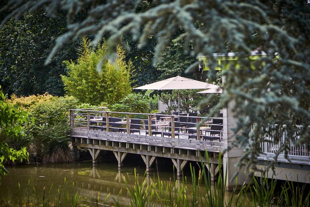 a bridge with a table and an umbrella on it at Les Jardins de l'Anjou in La Pommeraye
