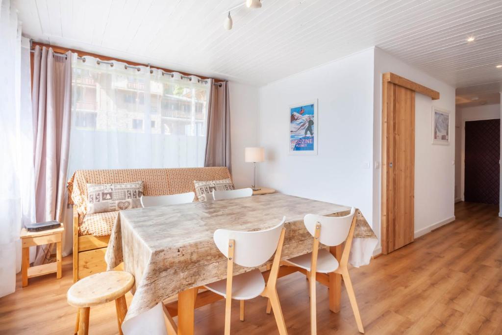 une salle à manger avec une table et des chaises en bois dans l'établissement Cimes 8, à Morzine