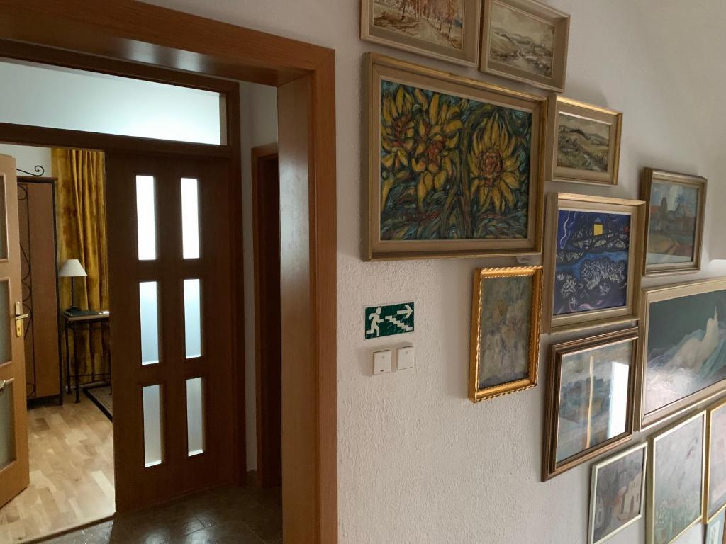a hallway with a bunch of pictures on a wall at Antik Hotel Sofia in Litomyšl