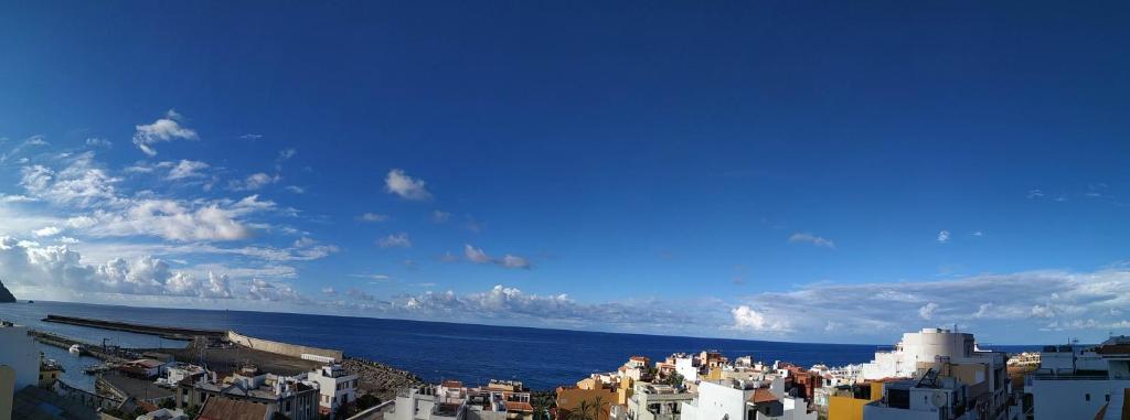 Blick auf eine Stadt mit Meer und Gebäuden in der Unterkunft Pension Candelaria in Valle Gran Rey