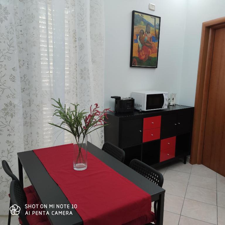 jadalnia ze stołem i wazonem w obiekcie La casa di Antonia w Katanii