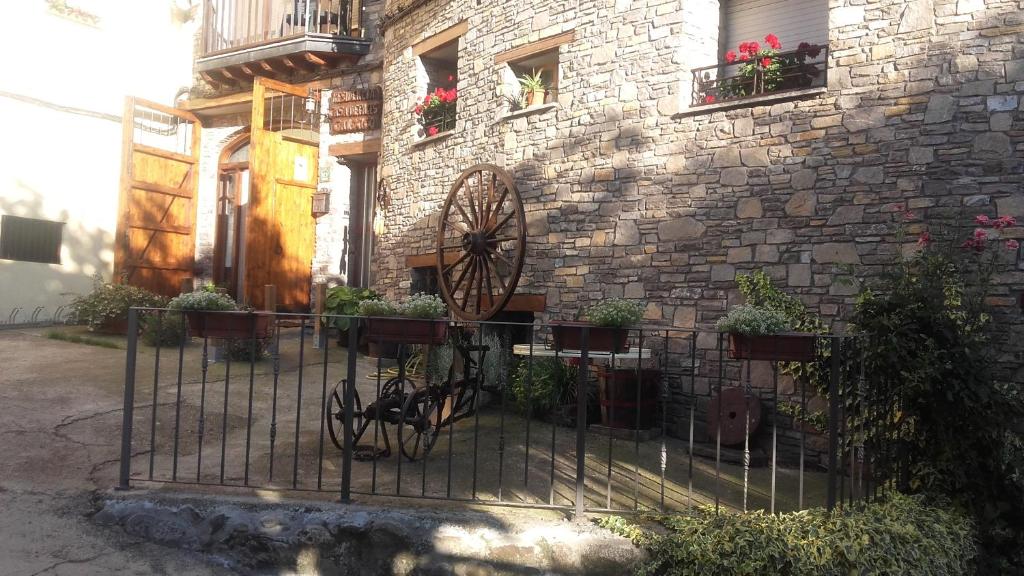 un edificio con una recinzione in ferro battuto con piante in vaso di Casa Rural Cal Xico ad Adrall