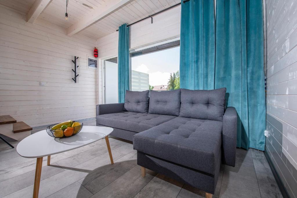a living room with a couch and a table at Domki MODERNO in Grzybowo