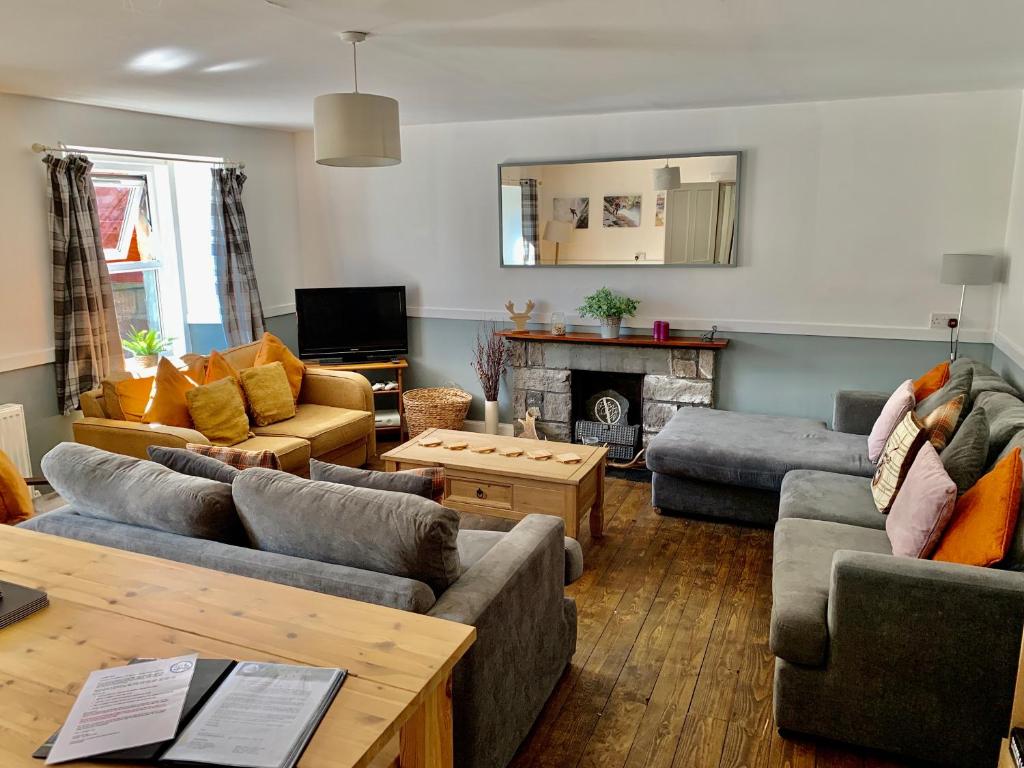 a living room with couches and a fireplace at Tay Bunkhouse in Pitlochry