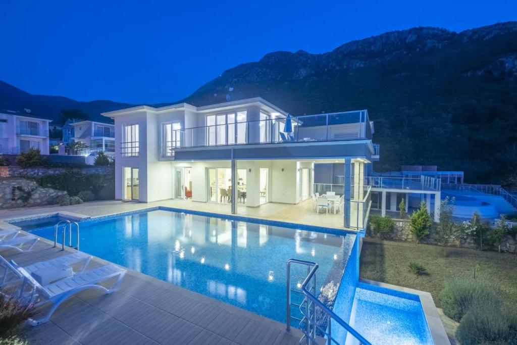 een groot huis met een zwembad in de nacht bij ORKA Prestige Villa, G in Fethiye