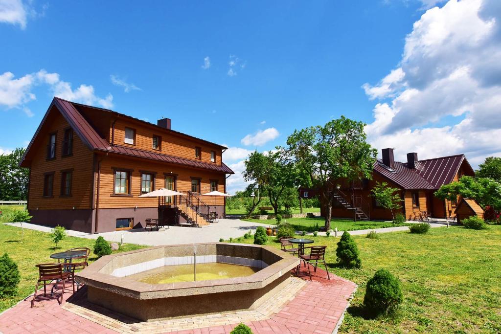 une maison avec une fontaine en face d'un bâtiment dans l'établissement "Trakaitis" apartments in Villa, à Trakai