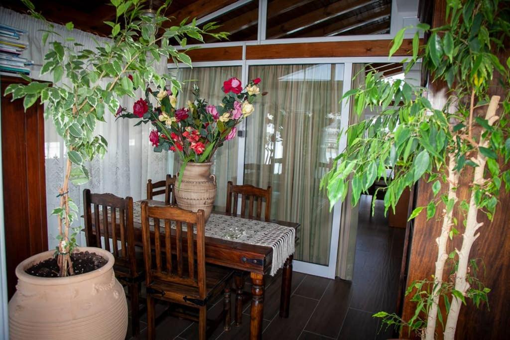 a table and chairs with flowers on a porch at STAVROS amazing apartment in the centre of KOS in Kos Town