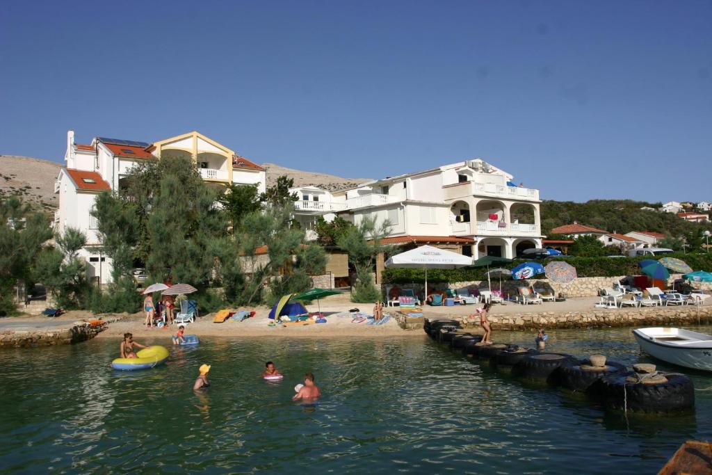 un grupo de personas en el agua en una playa en Guest House Frane en Pag