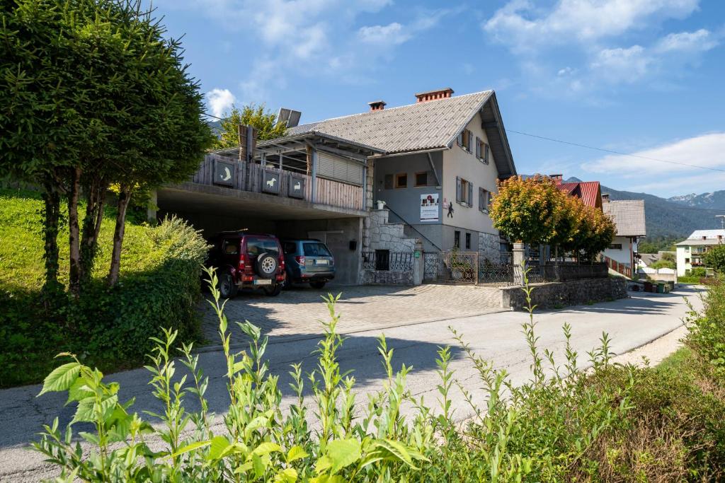 a house with a car parked in a driveway at Apartmaji Rauter in Bohinj