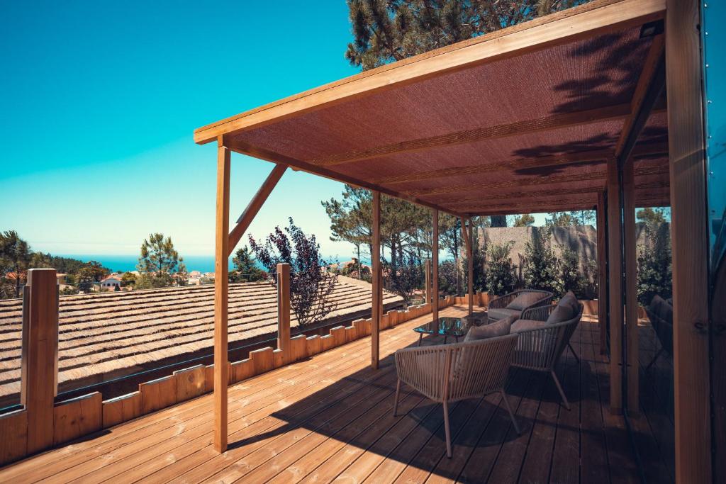 a wooden deck with a wooden pergola at Charm Nature in Azoia