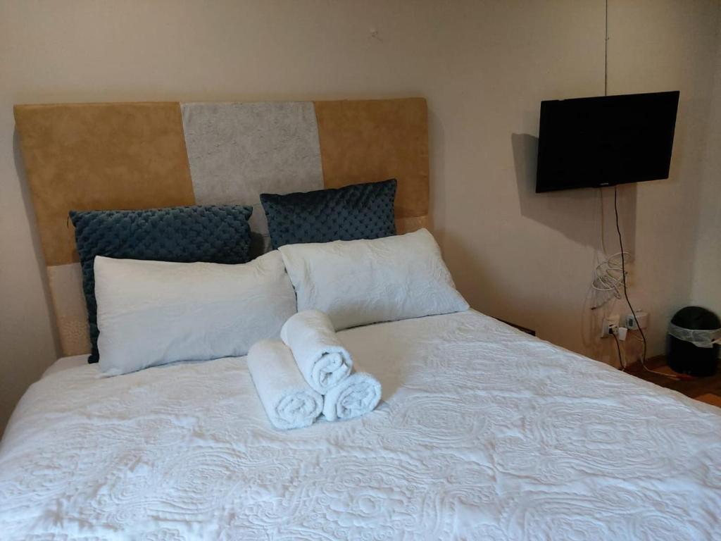 a bedroom with a bed with towels on it at Ikhutseng guesthouse and spa in Pretoria