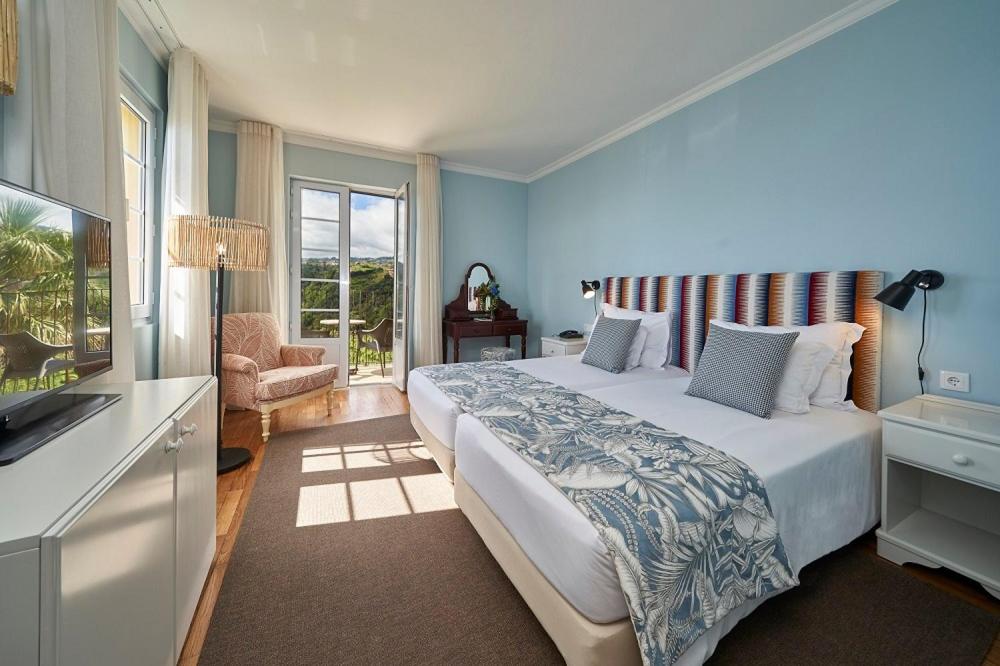 a bedroom with a large bed and a television at Hotel Quinta Do Furao in Santana