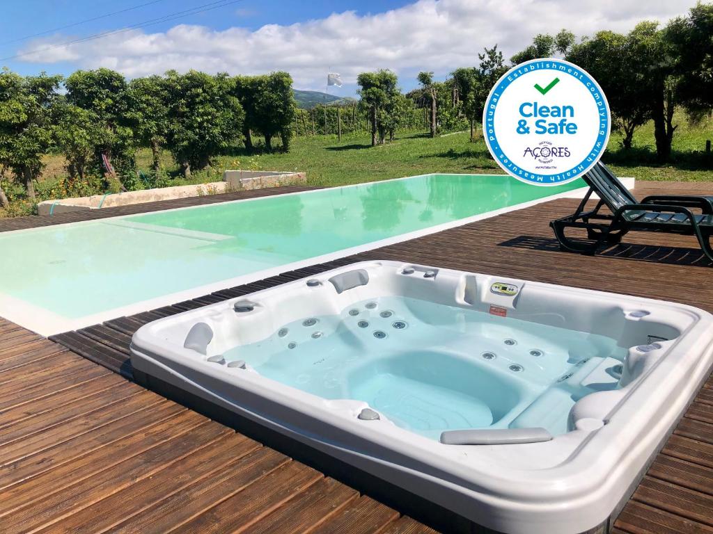 een hot tub op een terras met een bord dat zegt schoon en veilig bij Quinta dos Sabores Farm Houses in Ribeira Grande