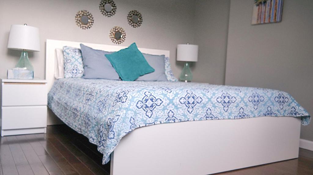 a bedroom with a bed with a blue and white bedspread at Sandy's Place NYC 1 in Brooklyn