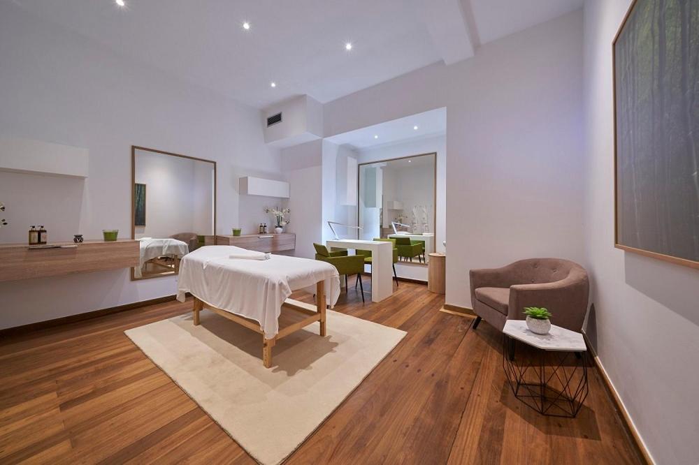 a living room with a table and a bedroom at Hotel Quinta Do Furao in Santana