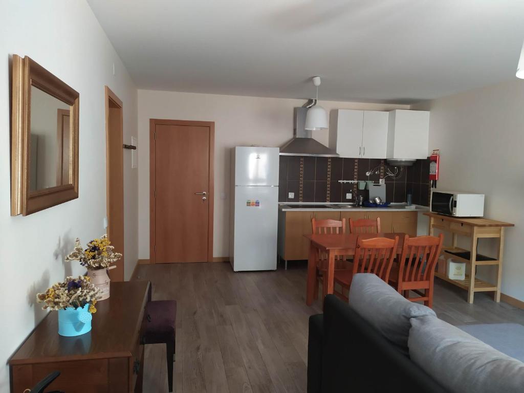 een woonkamer en een keuken met een bank en een tafel bij Casa da Rota dos Moinhos in Lousã