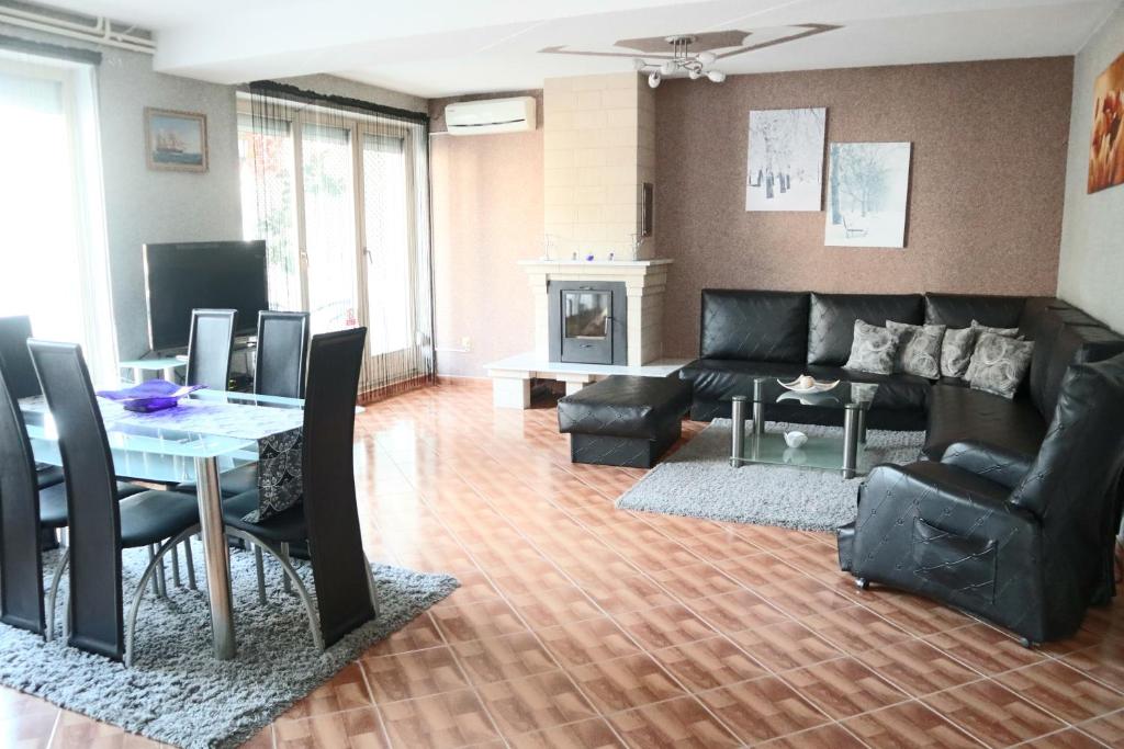 a living room with a black couch and a table at Sobe-Apartmani Modriča in Modriča