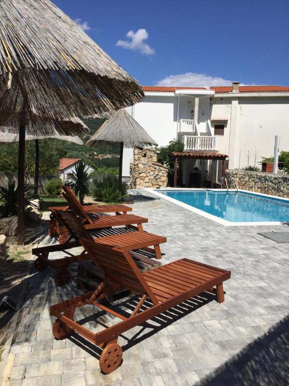 a group of deck chairs next to a swimming pool at Apartments Nora & Lucija in Baška
