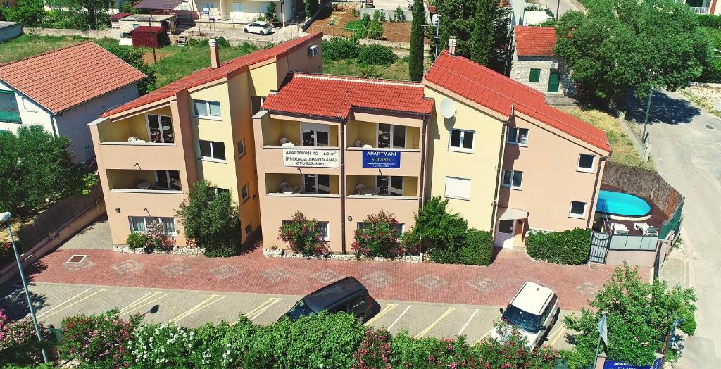 una vista aérea de un edificio de apartamentos con aparcamiento en Apartments Solaris, en Sveti Filip i Jakov