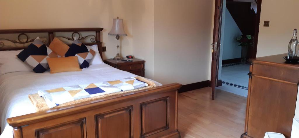 a bedroom with a wooden bed with pillows on it at Creevagh (Room Only) in Keel