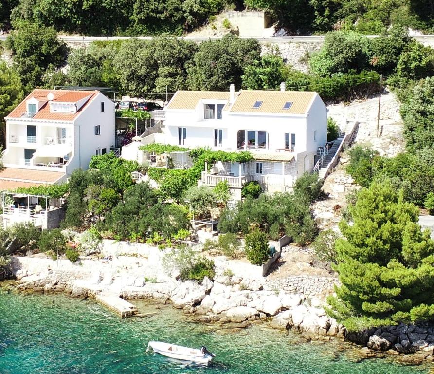 eine Luftansicht eines Hauses mit einem Boot im Wasser in der Unterkunft Sunset Apartments in Slano