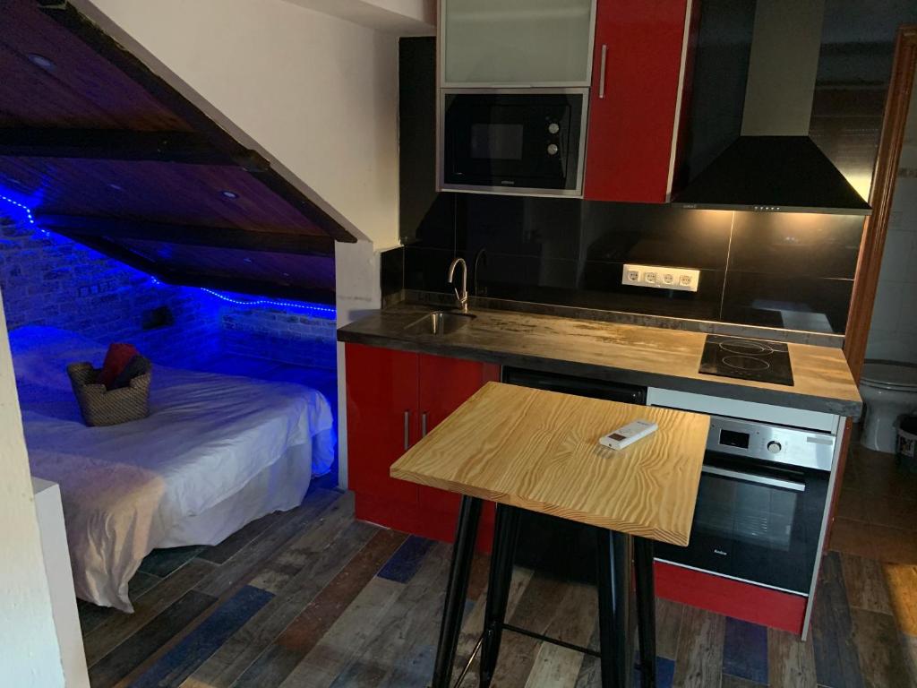 a kitchen with a sink and a bed in a room at Small Studio Inside a Penthouse on the Border in La Línea de la Concepción