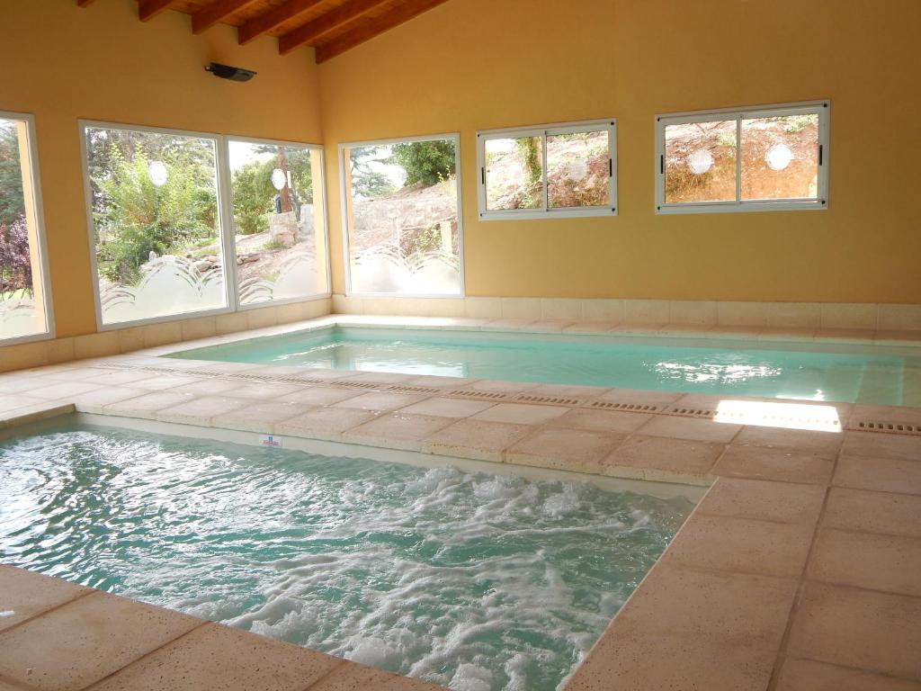 an indoor swimming pool with windows in a house at Las Terrazas Resort & Apart-Cabañas in La Falda