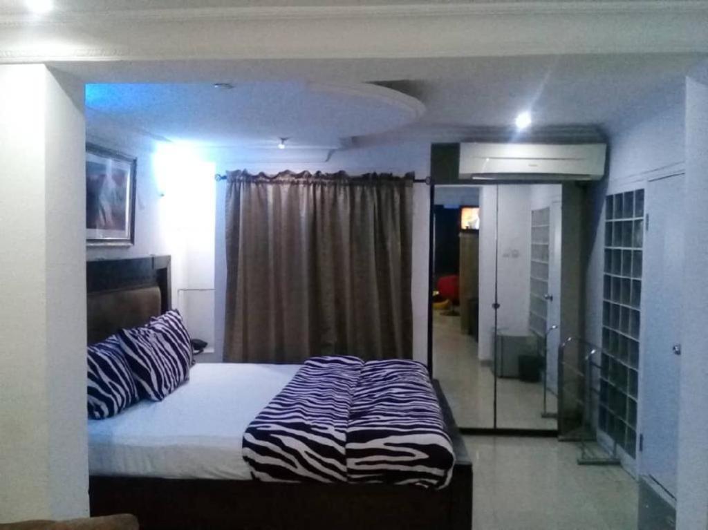 a bedroom with a bed with a zebra print sheets at TheoDawn Hotels @ Suite 29 in Ikeja