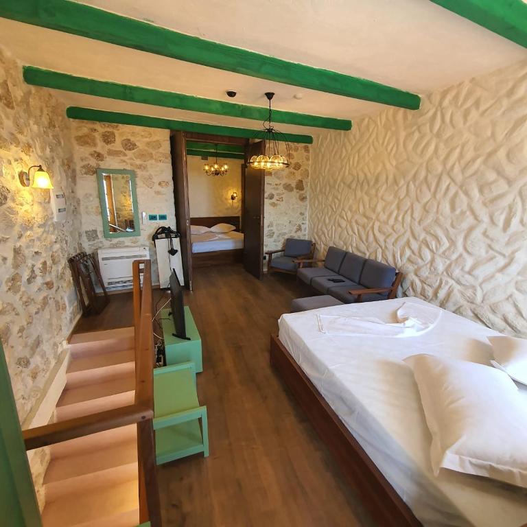 a bedroom with a bed and a living room at Roots Dhermi in Dhërmi
