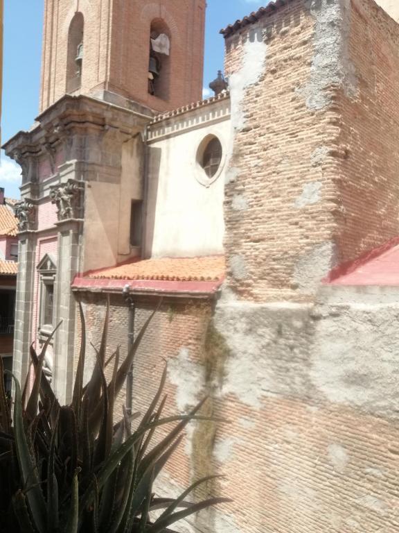 un edificio con una torre de reloj junto a una planta en Apartamento en el Rastro, en Madrid