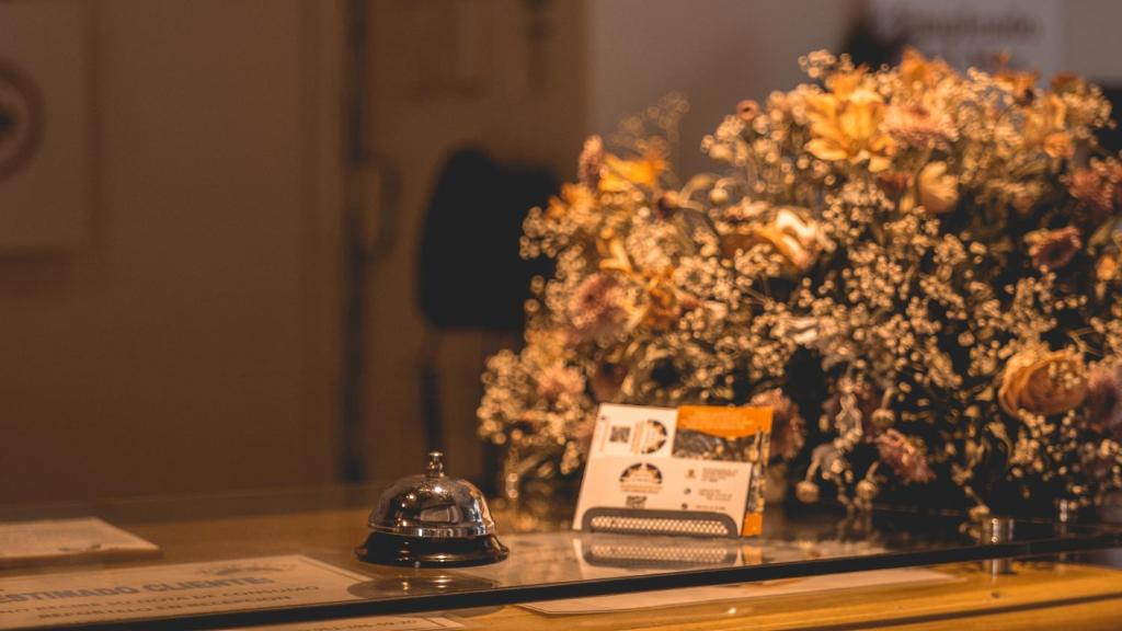 a table with flowers and a bell on it at Hotel Aurora in Oaxaca City