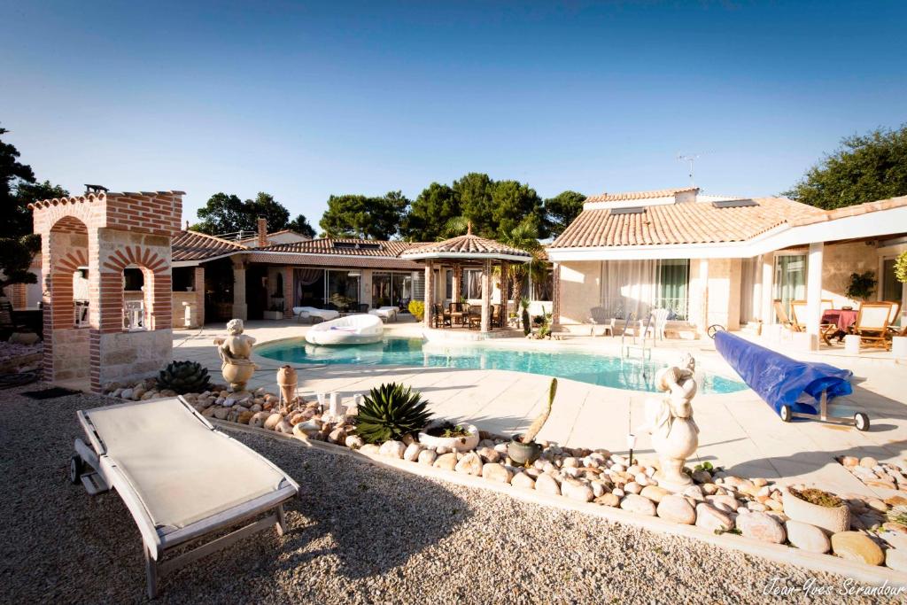 a house with a swimming pool in a yard at Le Mas des Mathes, Chambres d&#39;hôtes, Studios in Les Mathes