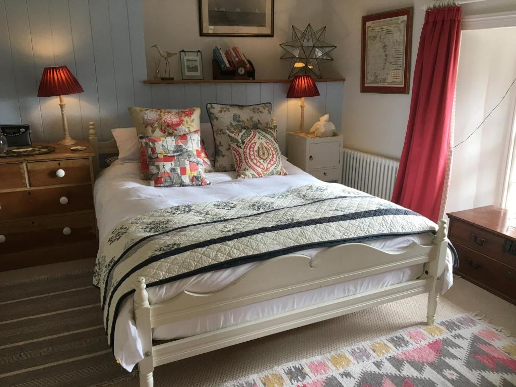 a bedroom with a white bed with pillows at Stroud House in Freshwater