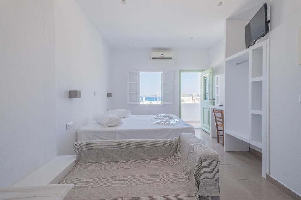 A bed or beds in a room at Lorenzo Studios and Suites Paros