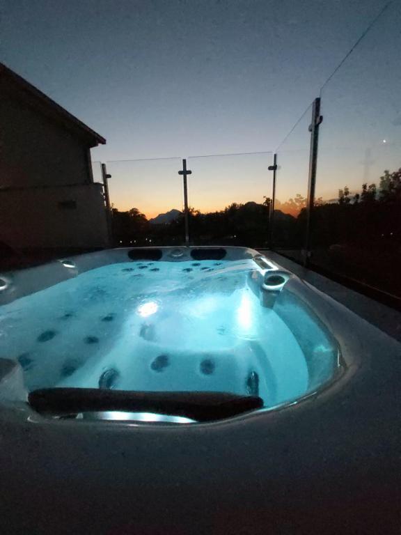 eine Whirlpool-Badewanne mit Sonnenuntergang im Hintergrund in der Unterkunft Summer House Nika with Jacuzzi in Slime