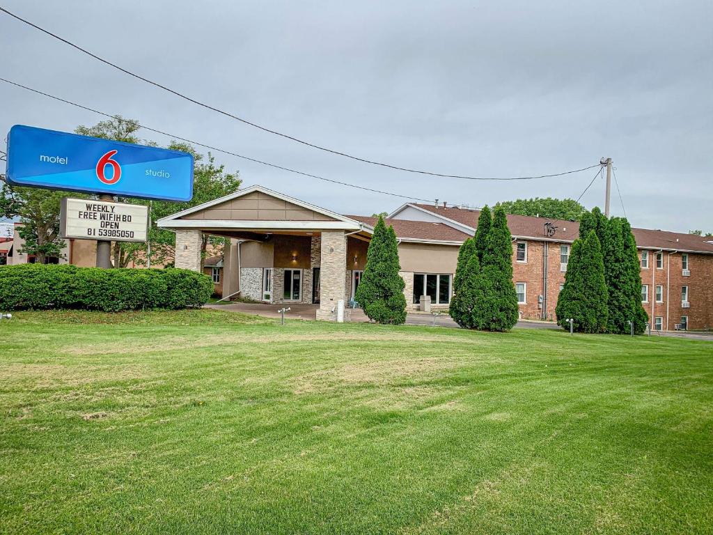 ein Gebäude mit einem blauen Schild vor einem Hof in der Unterkunft Motel 6 Rockford, Il in Rockford