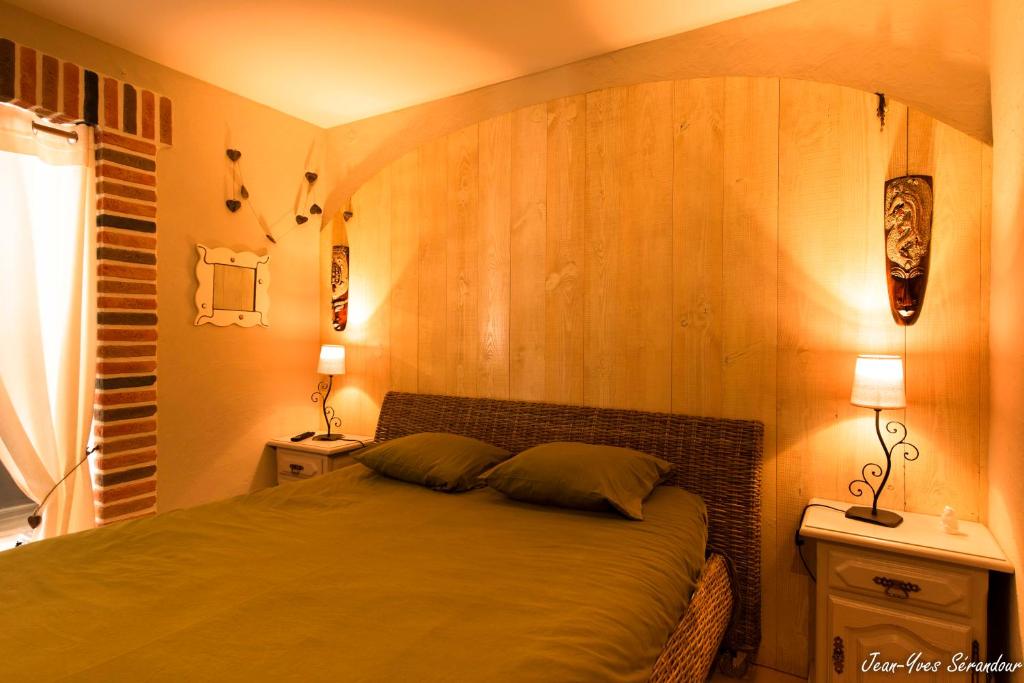 a bedroom with a bed with a wooden wall at Le Mas des Mathes, Chambres d&#39;hôtes, Studios in Les Mathes