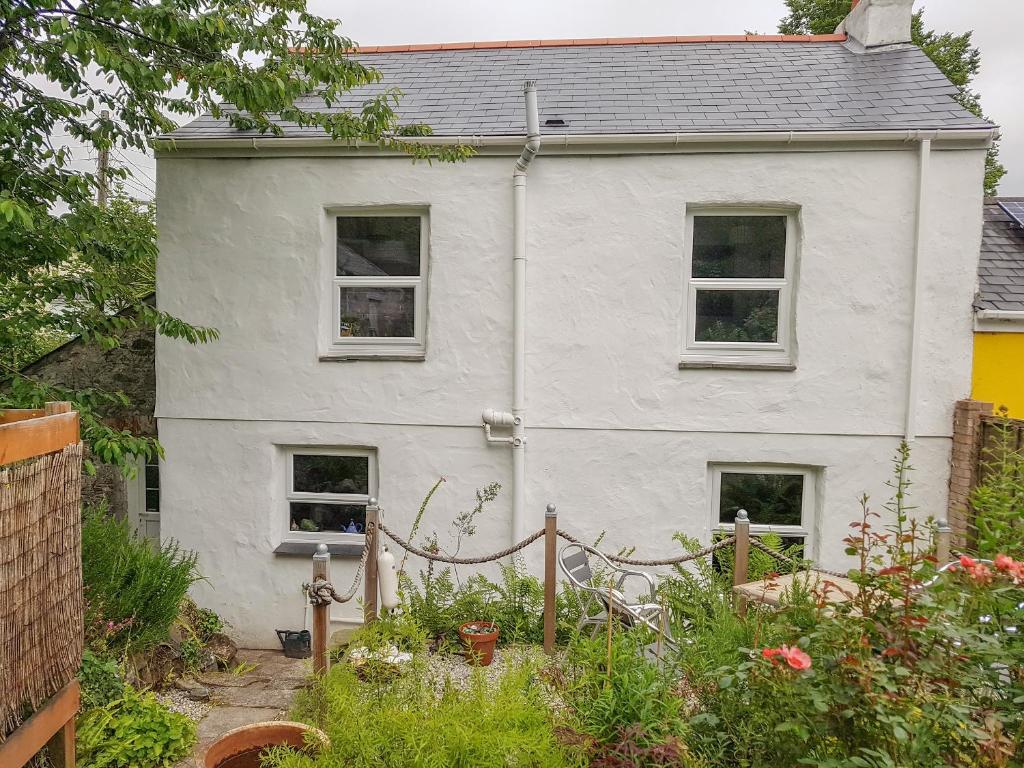 a white house with a garden in front of it at The Old Sweet Shop in Par