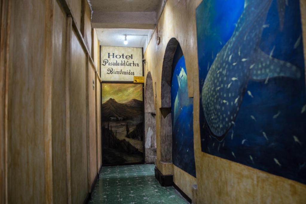 a hallway in a building with paintings on the walls at HOTEL POSADA DEL CORTEZ in La Paz