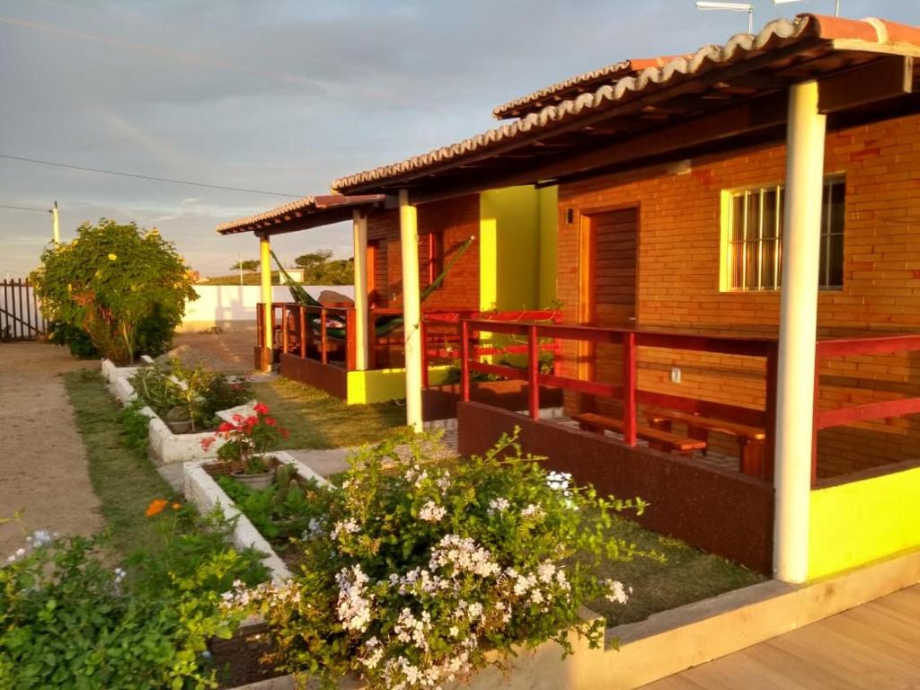 une maison avec des fleurs devant elle dans l'établissement Chalés Serra Monte, à Monte das Gameleiras