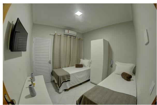 Habitación de hotel con 2 camas y lavamanos en HOTEL CASABLANCA, en Aparecida de Goiania