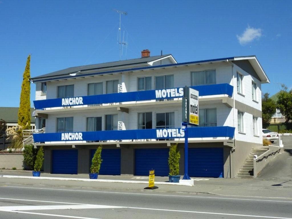 un edificio azul y blanco al lado de una calle en Anchor Motel, en Timaru