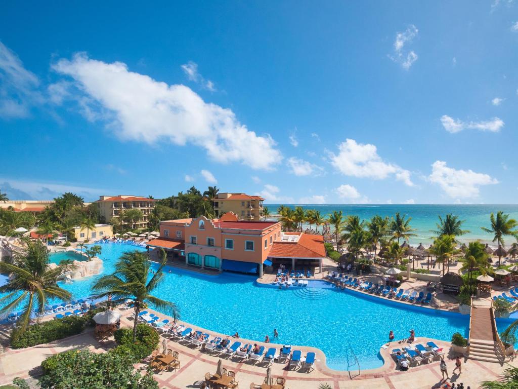 a beach scene with a large swimming pool at Hotel Marina El Cid Spa & Beach Resort - All Inclusive in Puerto Morelos
